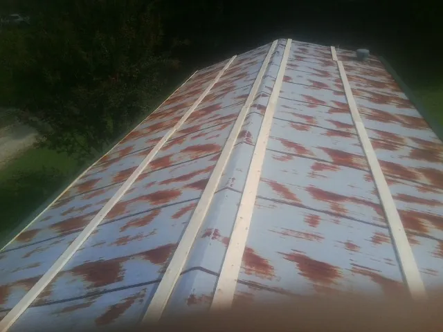 Rusted metal roof panels with new wood purlins before replacement — Storm Damage Roof Repair in Rockvale by Roofing Brothers